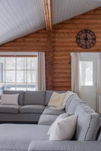 salon z kanapą i zegarem na ścianie w obiekcie Holiday in Lapland - Levisalmi A w mieście Levi