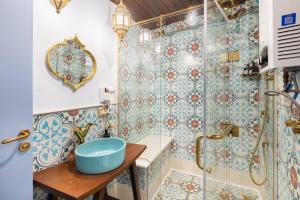 uma casa de banho com um chuveiro e um lavatório azul em The Majestic Marrakesh Studio Cairo's Downtown A no Cairo