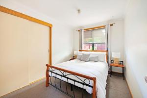 a bedroom with a bed and a window at Bay of Fires Great Escape in Binalong Bay