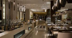 a restaurant with tables and chairs and chandeliers at InterContinental Phoenicia Beirut, an IHG Hotel in Beirut