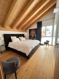 una camera con un grande letto e un soffitto in legno di The View a Flumserberg