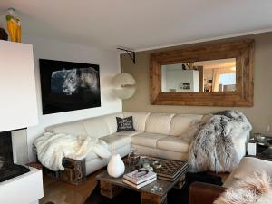 uma sala de estar com um sofá branco e uma mesa em The View em Flumserberg