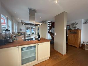 uma cozinha com armários brancos e um balcão de madeira em The View em Flumserberg