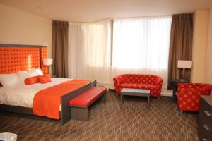 a hotel room with a bed and a chair at Hotel Chrome Montreal Centre-Ville in Montreal