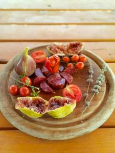 einen Teller mit Obst und Gemüse auf einem Holztisch in der Unterkunft KAMENGRAD CUPICA in Danilovgrad