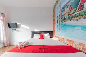 1 dormitorio con 1 cama y una gran pintura en la pared en RedDoorz Resort Syariah @ Jaya Tirta Abadi, en Purwakarta
