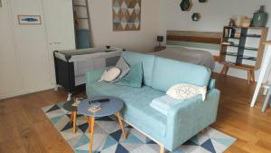 - un salon avec un canapé bleu et une table dans l'établissement Le Solidor vue mer, à Saint-Malo