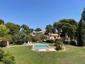 Bizanet的住宿－Ancien Mas viticole à 10 min de Narbonne，一个带游泳池和房子的花园