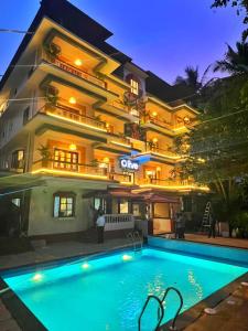 a hotel with a swimming pool in front of a building at Olive Calangute Niwasa - by Embassy Group in Calangute