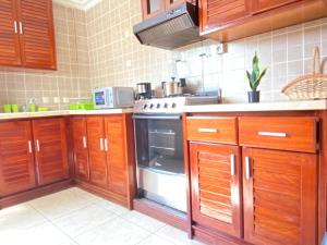 a kitchen with wooden cabinets and a stove at Armelle Sweet Home in Douala