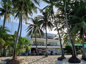 un hotel en la playa con palmeras en Sundown Resort & Austrian Pension House en Boracay