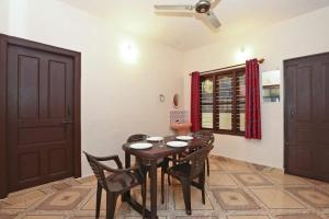 a dining room with a wooden table and chairs at AAdya. Homestay in Madikeri