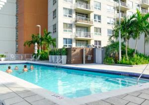 a swimming pool in front of a apartment building at Two Bedroom Apartment with Pool At Midblock Miami in Miami