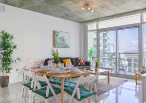 uma sala de jantar com uma mesa de madeira e cadeiras em Two Bedroom Apartment with Pool At Midblock Miami em Miami