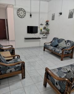 uma sala de estar com dois sofás e uma televisão em E3 Summer Homestay 夏之屋 em Kudat