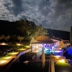 ein Haus mit Sonnenschirmen und einem Pool in der Nacht in der Unterkunft La Quercetta in Foligno