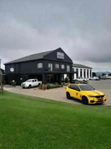 een gele auto geparkeerd voor een zwart gebouw bij Protea Hotel by Marriott Harrismith Montrose in Harrismith