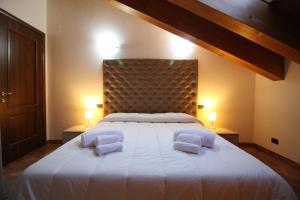 una camera da letto con un grande letto bianco con due cuscini di Attico dell'Aquila a Brusson