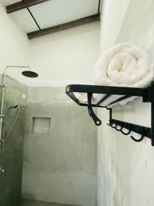 een handdoekenrek in een badkamer met een douche bij UMAAY ViLLAS - Paddyfield Hideout in Hikkaduwa
