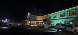 un edificio con auto parcheggiate di fronte ad esso di notte di Protea Hotel by Marriott Harrismith Montrose a Harrismith