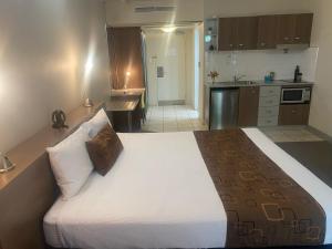 a bedroom with a large bed and a kitchen at Water Front Townsville in North Ward