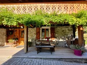 a patio with a wooden table and a bench at La montagnarde des Sapins Blancs in Vacheresse
