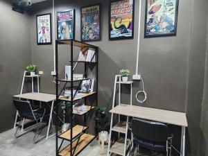 a room with tables and chairs and posters on the wall at Dfeel House in Patong Beach