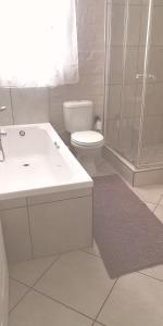La salle de bains blanche est pourvue d'une douche et de toilettes. dans l'établissement BoHo, à Velddrif