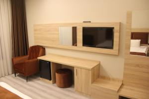 a room with a desk and a tv on a wall at Arhavi Resort Otel in Arhavi