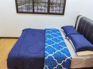 uma cama com um cobertor azul em cima em New Renovated 4 min to Aeon Big, starbuck 2B2R em Batu Pahat