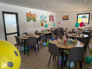 a party room with tables and balloons on the walls at Lumea Copiilor Karina&Adelin Lupeni in Lupeni