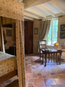 a bedroom with a table and a bed and a desk at Domaine de Rennebourg in Saint Denis Du Pin