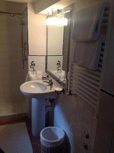 a bathroom with a sink and a mirror and a shower at Appartamento Michelangeli-Private parking in Orvieto