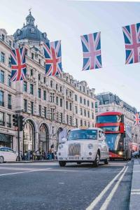 a white car driving down a street with british flags at THE VIEW by condokeeper in London