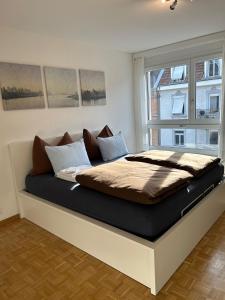 a large bed in a room with a large window at Guesthouse Elisa 6 in Zurich