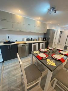 een keuken met een eettafel en een keuken met witte kasten bij Double D Apartments in Lupeni