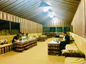a group of people sitting at tables in a room at Serenity Camp in Wadi Rum +29 photos