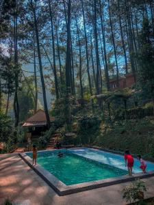 a group of people standing around a swimming pool at Kampung Rimba by Anrha in Bogor