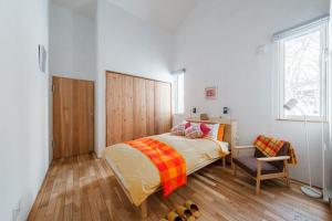 a bedroom with a bed and a chair at 6ty6 - Vacation STAY 18030v in Niseko