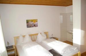 2 Betten mit weißen Kissen in einem Zimmer in der Unterkunft Haus Brigitte Rettensteiner in Schladming