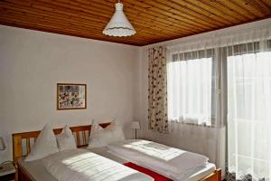 um quarto com uma cama e uma janela em Haus Brigitte Rettensteiner em Schladming