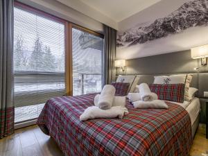 a bedroom with a bed with towels on it at VisitZakopane - Royal Resort Wellness & SPA in Zakopane