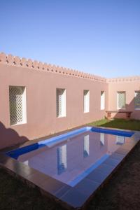 a swimming pool in front of a house at Shahpura Gandharva Retreat, Sariska in Alwar