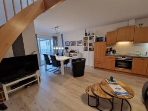 a large living room with a table and a kitchen at Haus Seewind Wohnung 3 in Cuxhaven