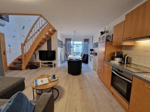 a living room with a kitchen and a staircase at Haus Seewind Wohnung 3 in Cuxhaven