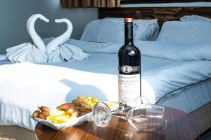 Haifa Tower Hotel - מלון מגדל חיפה في حيفا: زجاجة من النبيذ وصحن من الطعام على طاولة