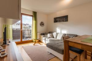 a living room with a couch and a table at FaWa Apartments "Villa Mai" in Brunico