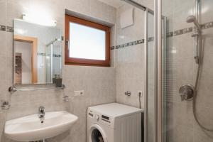 a bathroom with a sink and a washing machine at FaWa Apartments "Villa Mai" in Brunico +14 photos