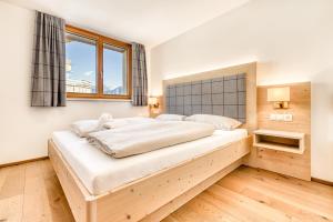 ein Schlafzimmer mit einem großen Bett in einem Zimmer in der Unterkunft Appartements im Kirchberg by A-Appartments in Fontanella