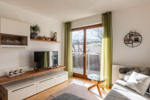 a living room with a couch and a tv at FaWa Apartments "Villa Mai" in Brunico